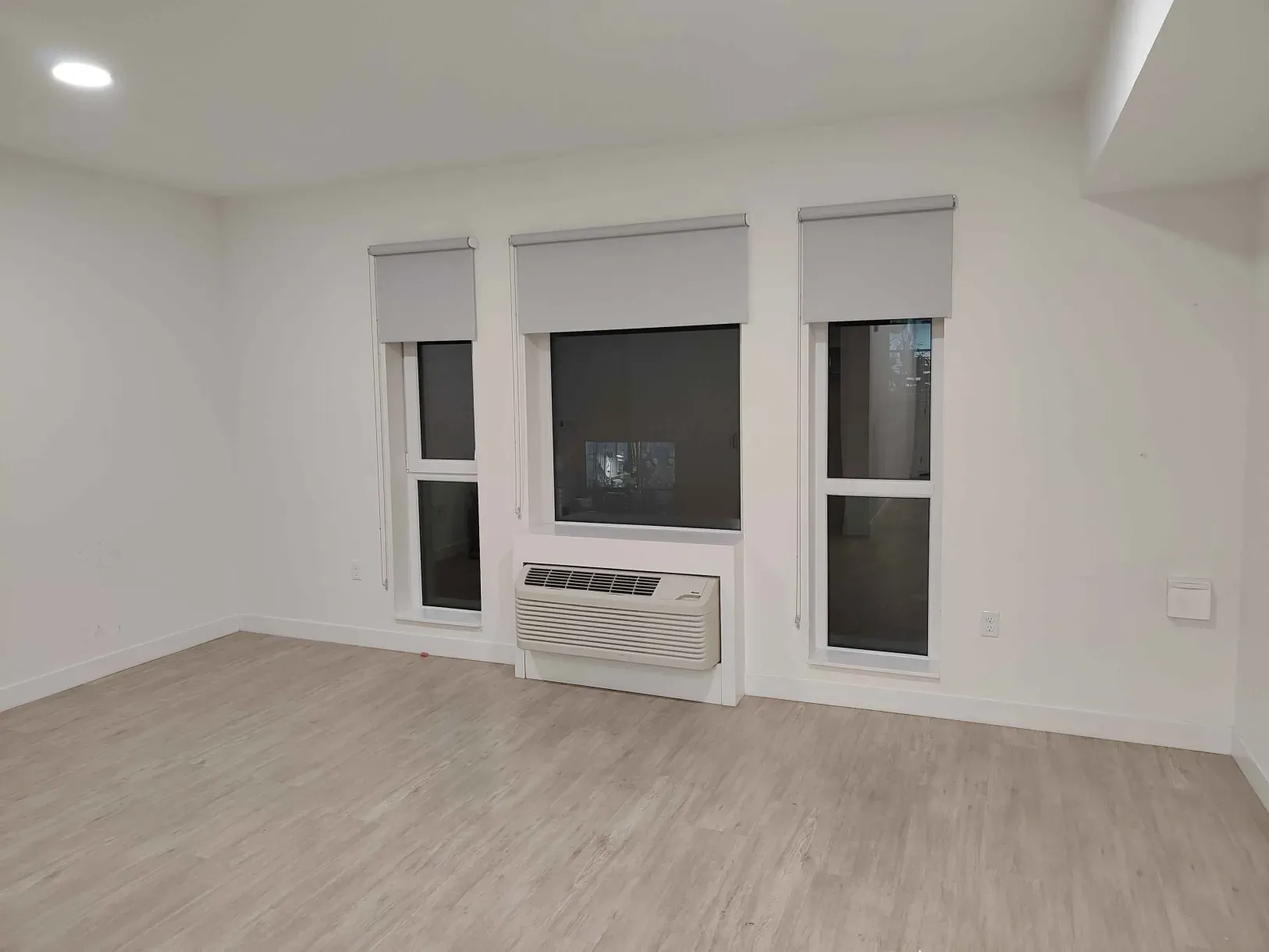 A picture of our Washington apartment's living room, which connected the kitchen and bedroom. There are 3 large windows that look out on the courtyard.